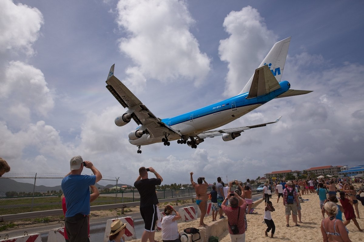 Image of a plane landing over a group of people with an ON1 preset applied