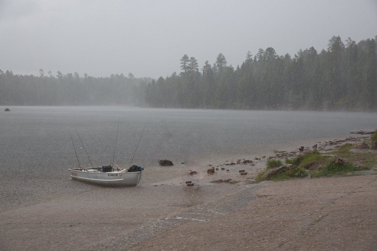 Edited landscape image of a boat beside a lake in the rain